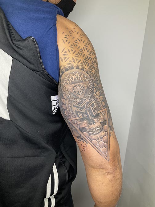 Tatuaje masculino con significados espirituales o de conexión interior, geometría sagrada en el brazo
