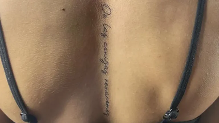 Tatuaje en la columna para mujer de una frase en la espalda