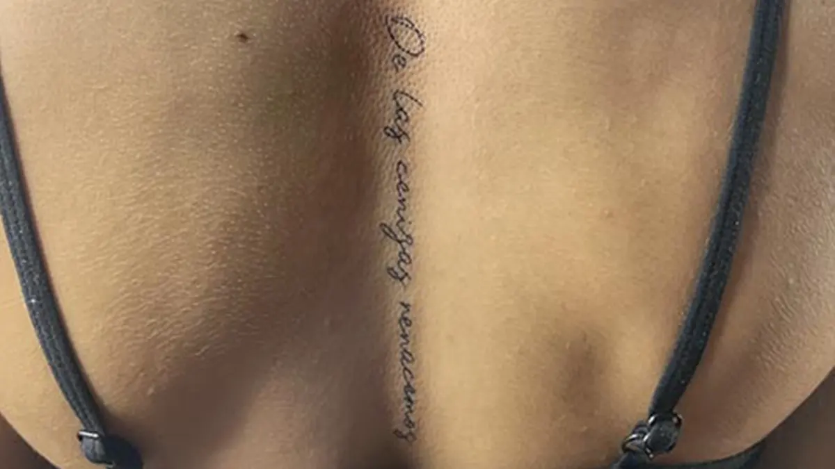 Tatuaje en la columna para mujer de una frase en la espalda