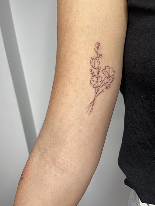 Ramo de flores en el brazo, tatuajes fine line