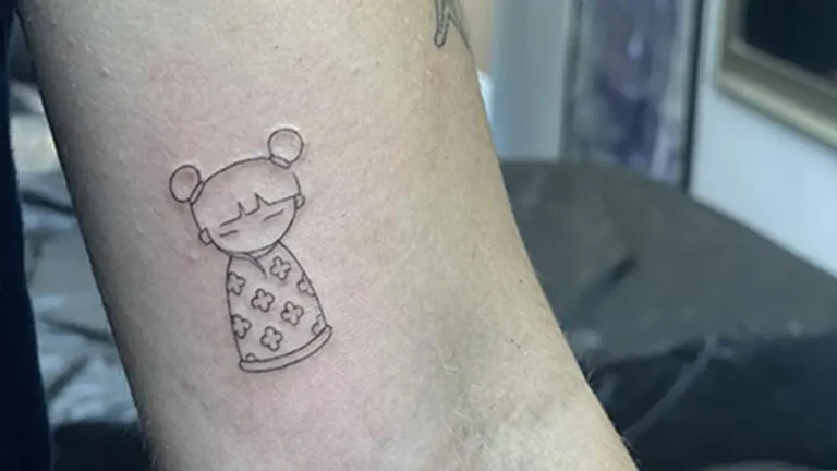Tatuaje estilo fine line de una muñeca en el brazo