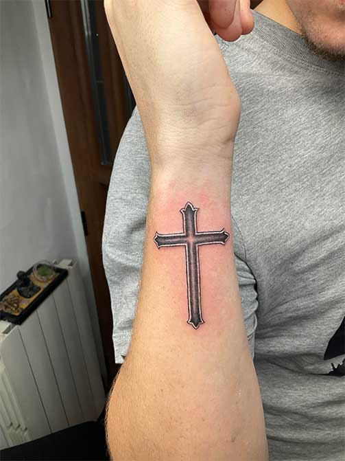 Tatuajes pequeños para hombres de cruz en el antebrazo