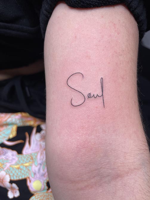 Tatuaje pequeño para mujer en el brazo de una palabra