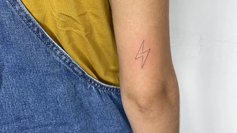 Tatuaje pequeño para mujer en el brazo de la silueta de un rayo